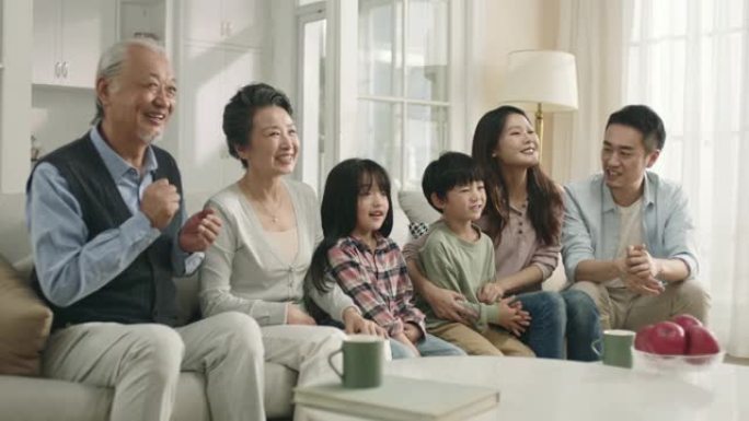 三代亚洲家庭在家看电视