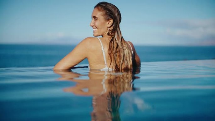 女人在豪华度假村的游泳池里放松