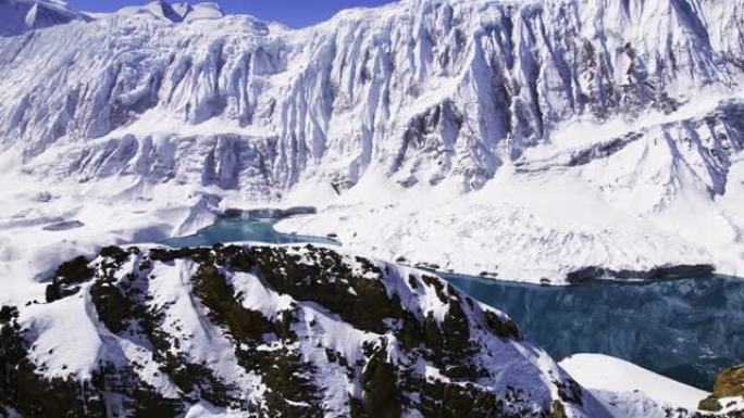 尼泊尔积雪覆盖的山脉景观，在明亮的阳光下有一个高山湖泊。从鸟瞰图看蒂利乔湖