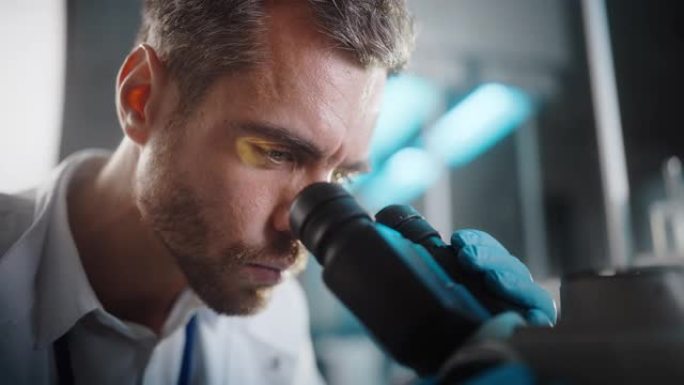 在明亮的医学科学实验室: 英俊的微生物学家在显微镜下分析样本的肖像。才华横溢的科学家，与高科技设备合