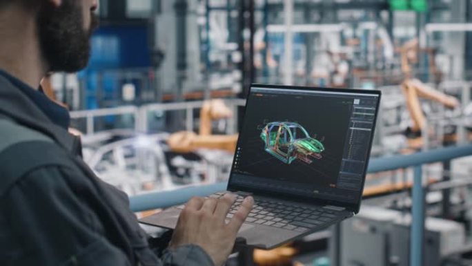 汽车工厂工程师在工作制服中使用带有数字3D CAD车辆蓝图的笔记本电脑。从事汽车生产的汽车工业制造工