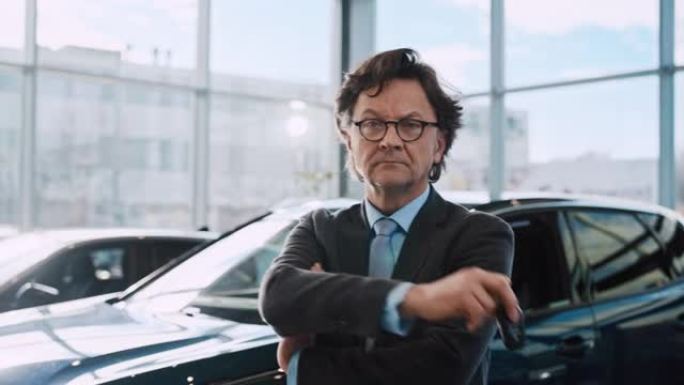 一位成功的汽车推销员的SLO MO肖像在汽车陈列室中双臂交叉摆姿势