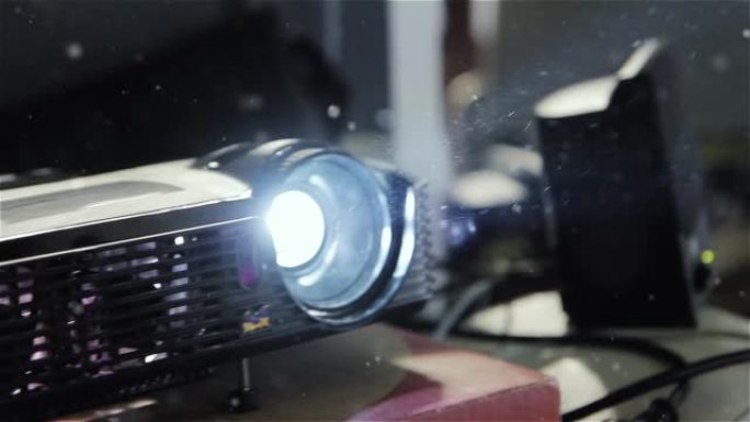 视频投影仪在黑暗的教室里工作。空气中的灰尘颗粒。特写。