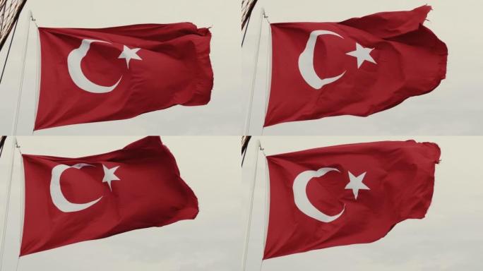 美丽的土耳其国旗的低角度特写，在灰色多云的天空背景下，国家标志在大风中挥舞着杆子。