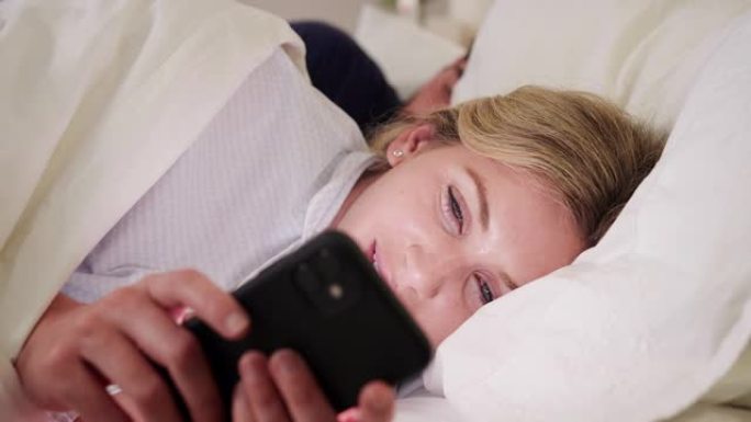 夫妻女子晚上躺在床上看手机屏幕