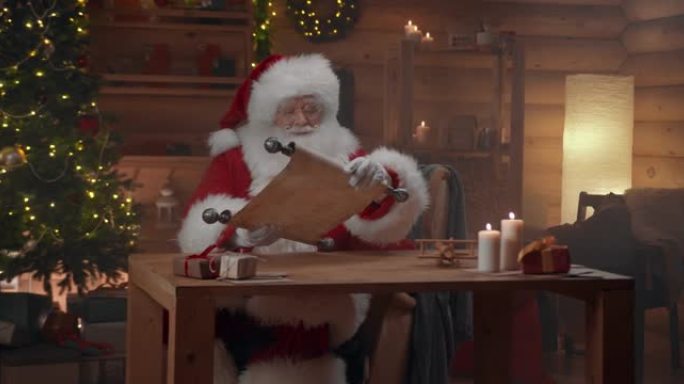 圣诞老人坐在装饰精美的小屋中，用好孩子的名字展开卷轴