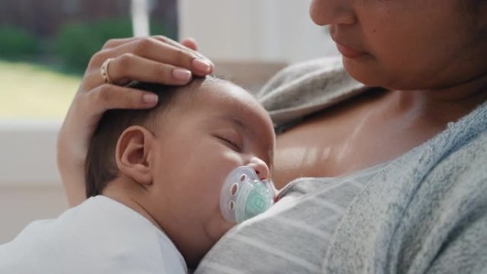 婴儿安静地睡在母亲的怀抱中慈爱的母亲抱着婴儿在家照顾困倦的幼儿4k