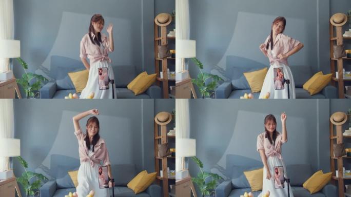 快乐年轻的亚洲女孩博主手机摄像头录制视频在家客厅享受舞蹈内容。社会距离冠状病毒大流行概念。自由和积极