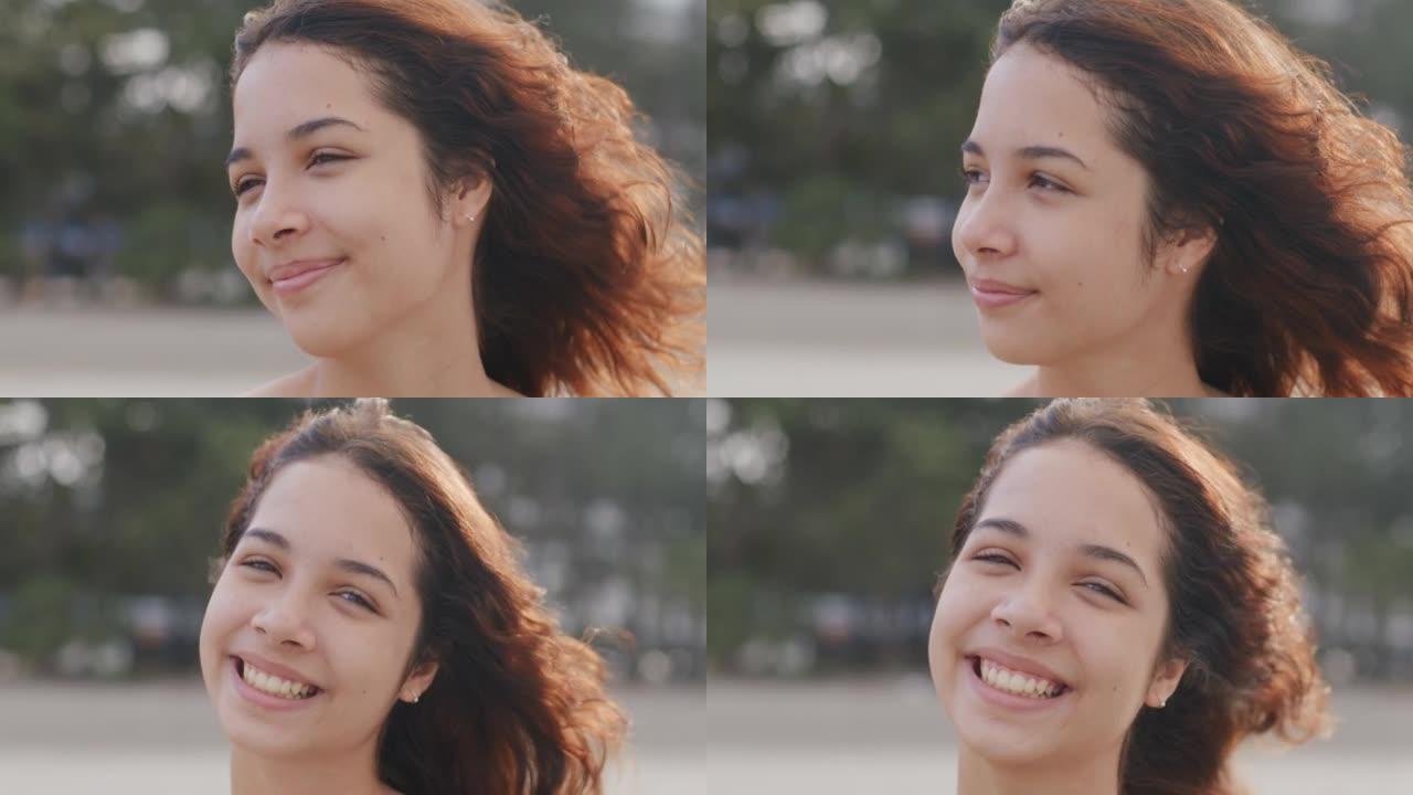 年轻的少女放松并微笑着看着海滩上的相机