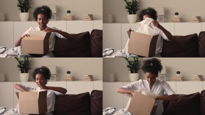 开朗的年轻非洲混血女子打开纸板箱。