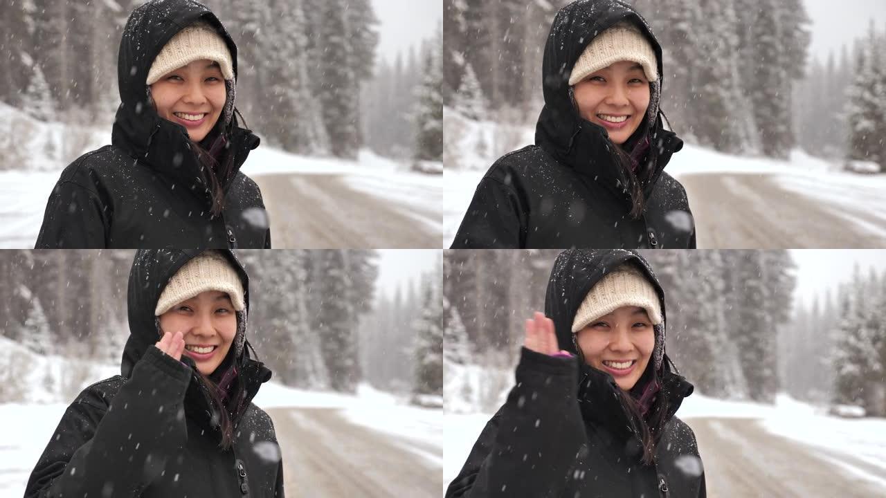 亚洲妇女在下雪时看着相机的肖像