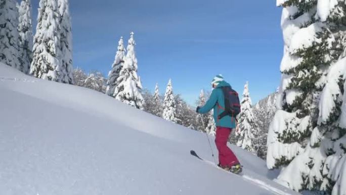 复制太空女人在滑雪旅行中徒步上山时踩着深雪