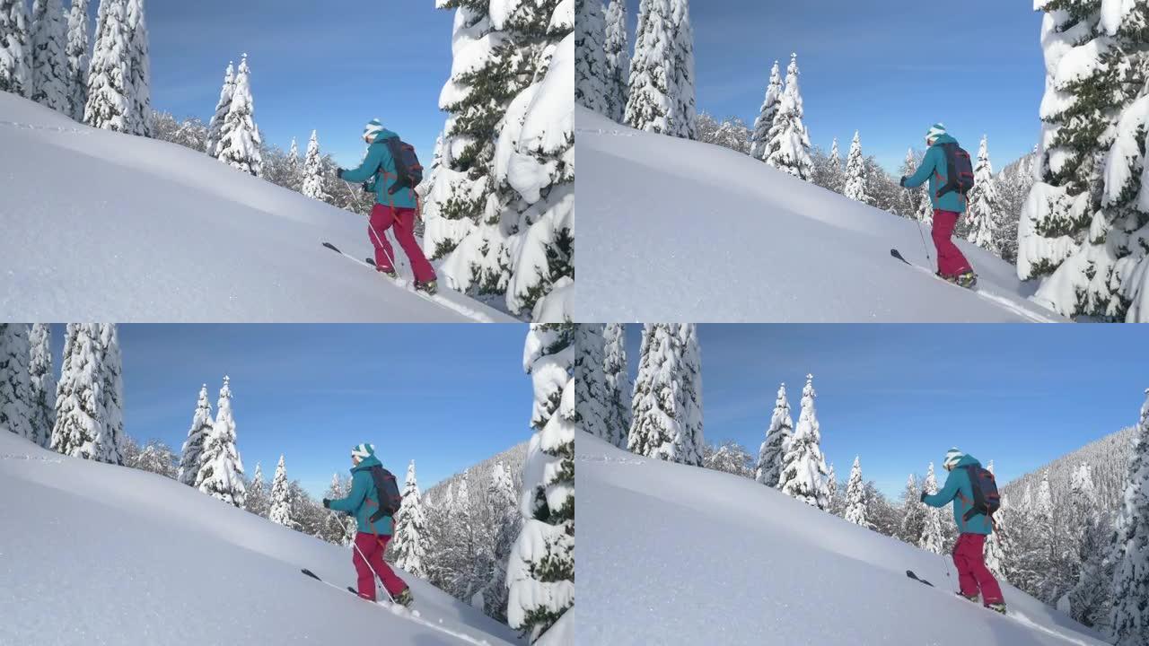复制太空女人在滑雪旅行中徒步上山时踩着深雪