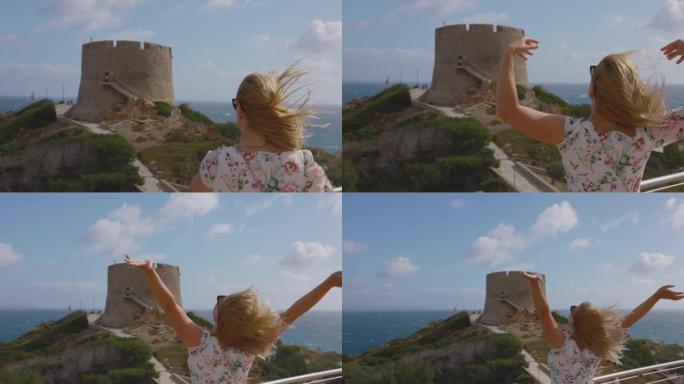 撒丁岛，一个张开双臂的金发女人的慢动作视图。