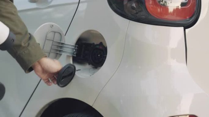 男性使用电动汽车充电站系统，现代汽车技术。