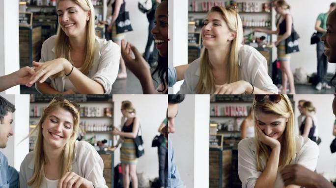 一段4k视频，一名迷人的年轻女子和她的朋友坐在咖啡馆里，展示她的订婚戒指