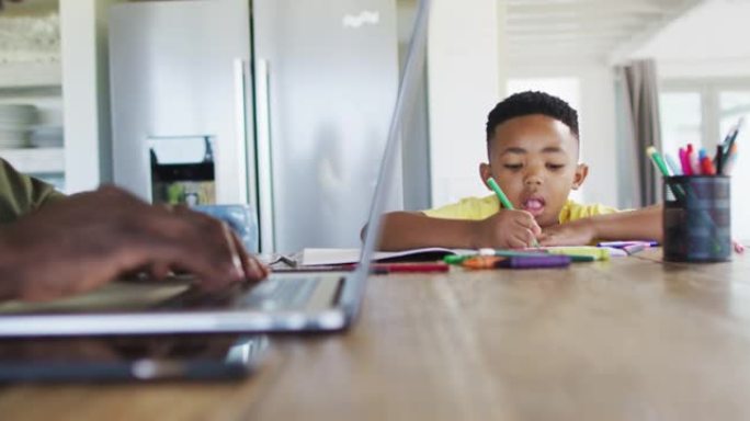 非裔美国人父子一起做作业和使用笔记本电脑