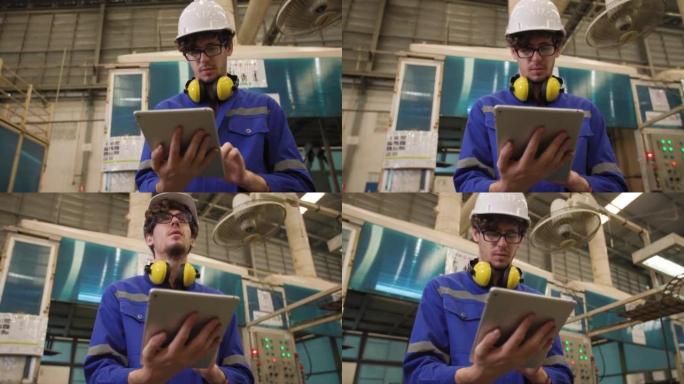 工业工程师使用平板电脑控制自动化机器人手臂的低角度拍摄