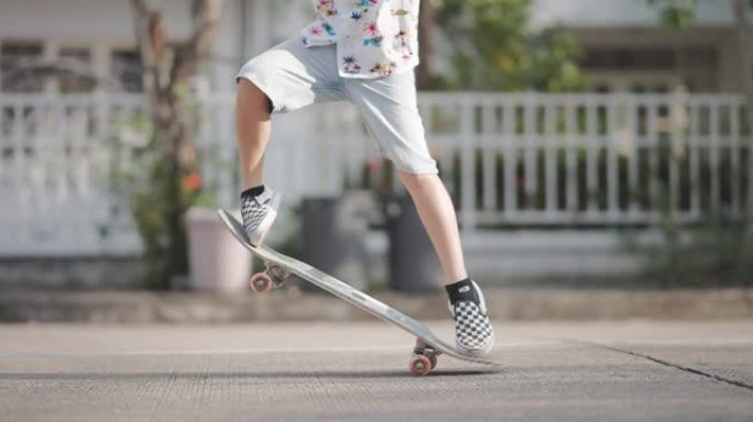 玩滑板的亚洲男孩少年练习技术高难度起跳