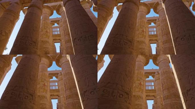 埃及卢克索的卡纳克神庙。带有古埃及图纸的雄伟圆柱。相机在带有古埃及图纸的列之间移动
