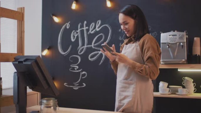 咖啡卖家在智能手机上滚动供稿