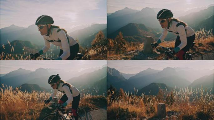 女骑车人在阳光明媚的山区骑自行车