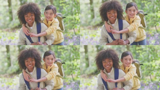 男孩和女孩穿着背包的肖像一起走在春天的林地