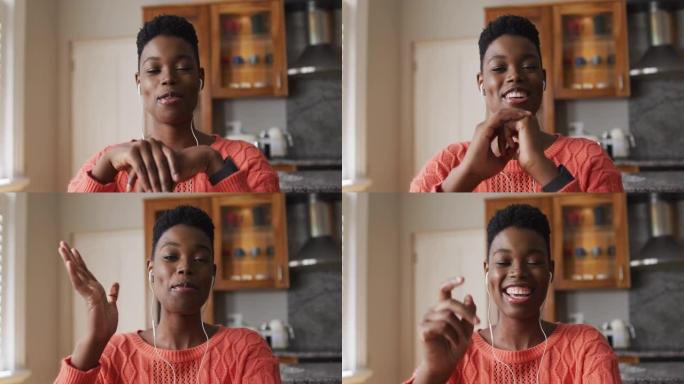 非裔美国妇女戴着耳机说话的肖像在家里看着相机