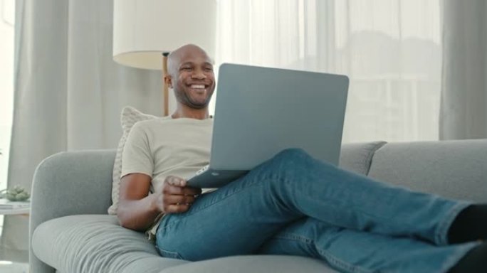 4k视频片段，一个男人的鞋子躺在地板上，而他用笔记本电脑在沙发上放松