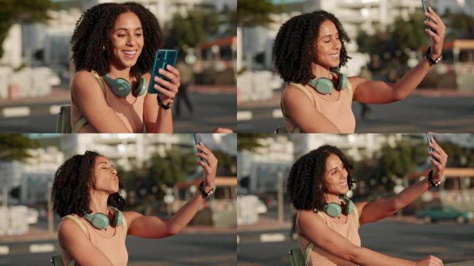 自拍，黑人妇女和电话在户外戴着耳机在城市里开心，交流和微笑。女士，女孩和智能手机进行视频通话，放松和