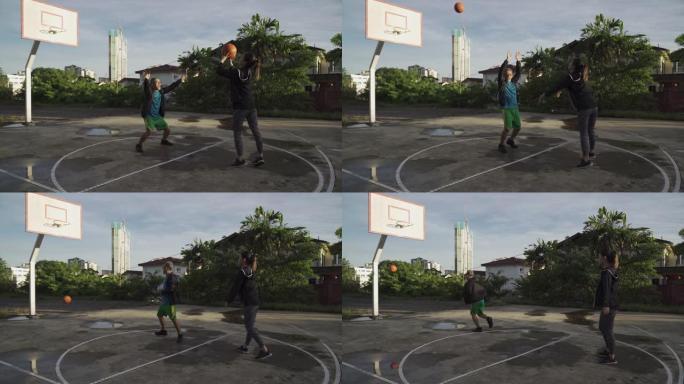 一名亚洲华裔资深男子上午与女儿在篮球场练习篮球赛