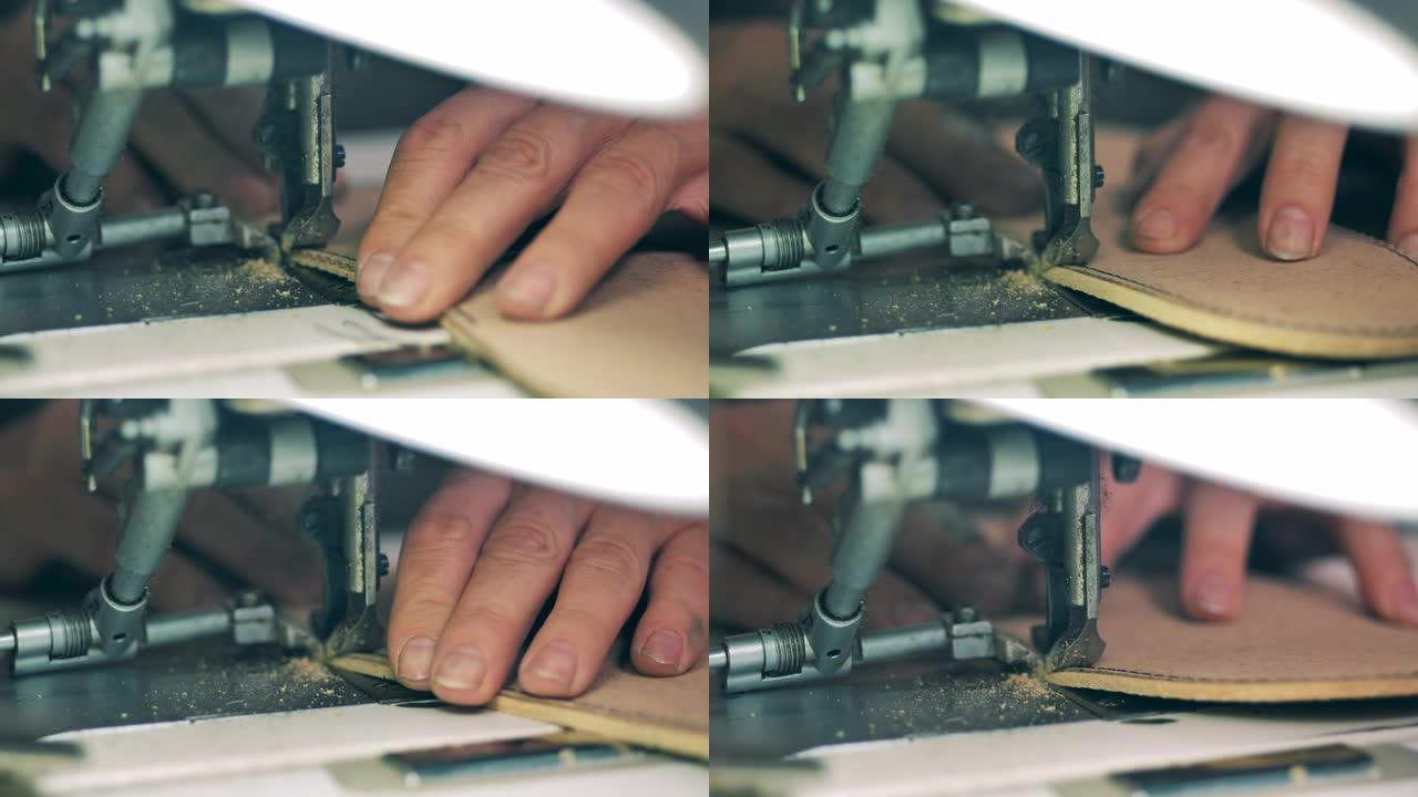 一个人正在用缝纫机缝制鞋底