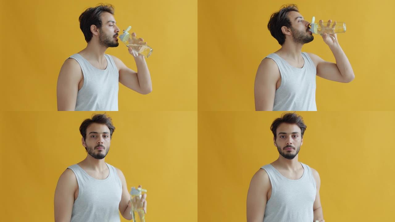 印度年轻运动员的慢动作肖像从瓶子里喝水，然后看着相机微笑