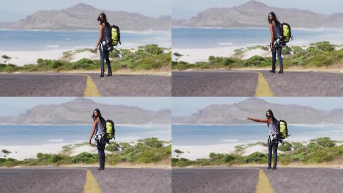 背着背包的非裔美国妇女试图在路上行走时搭便车