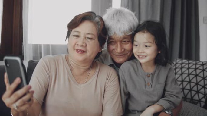 亚洲祖父母和孙子微笑自拍照。