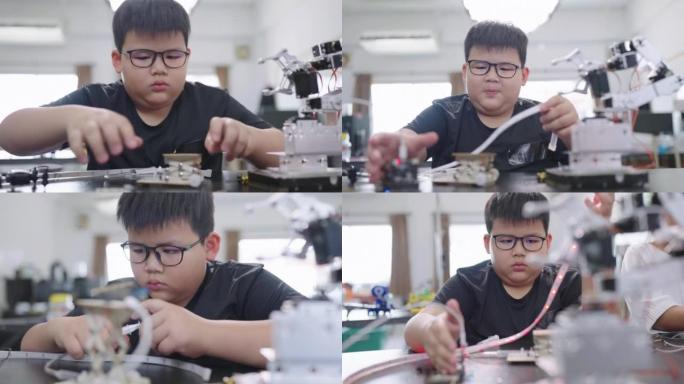 在科学课上学习压力并触摸塑料管以控制机器压力的小男孩。