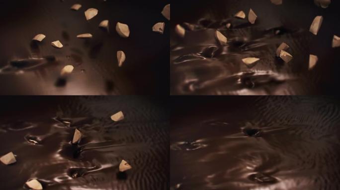 榛子碎片在4k超慢动作中溅到液体黑巧克力中