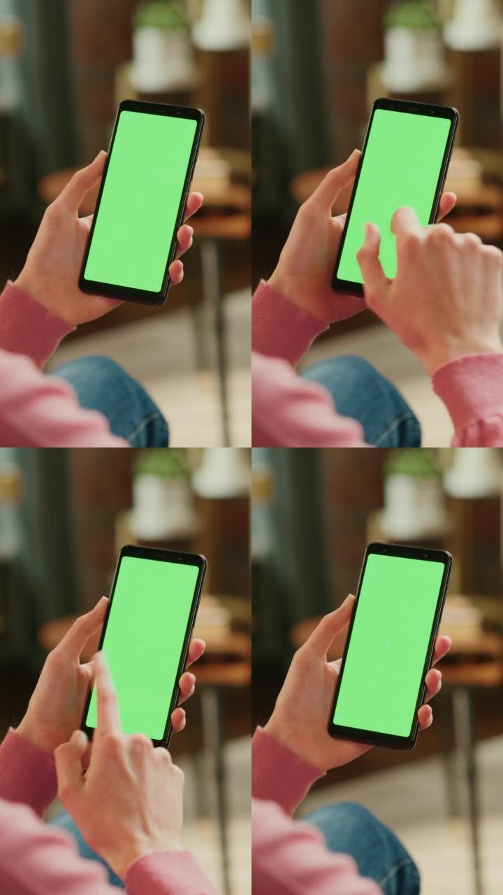 垂直屏幕: 带有绿色屏幕模拟显示的智能手机上的女性手动滚动供稿。女性在家休息，并在移动设备上查看社交