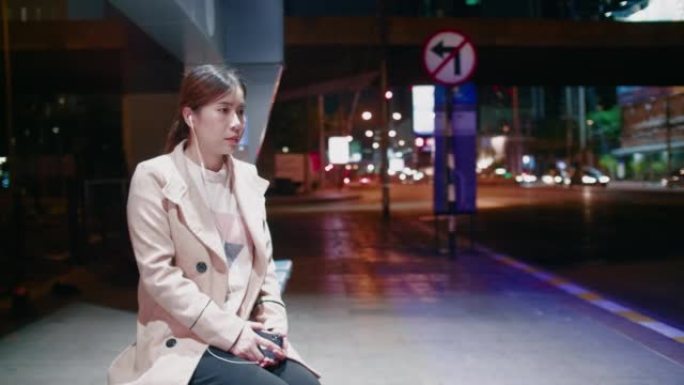 抑郁症妇女在晚上感到悲伤的公共汽车站