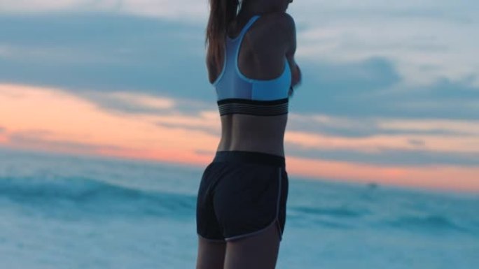 健康，活跃和运动的女人伸展，准备并准备在日落时在海滩上锻炼，锻炼和训练。在海边奔跑的早晨，认真，积极