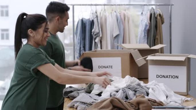 4k录像，两个人穿着绿色t恤，同时折叠衣服以装在捐款箱中