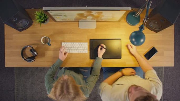 男性和女性平面设计师或带有图形平板电脑的照片润饰器的俯视图夜间在创意办公室工作-慢动作拍摄