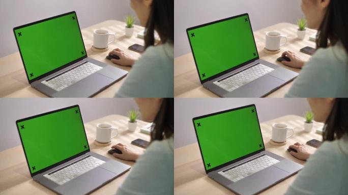 亚洲女性使用色度键屏幕笔记本电脑