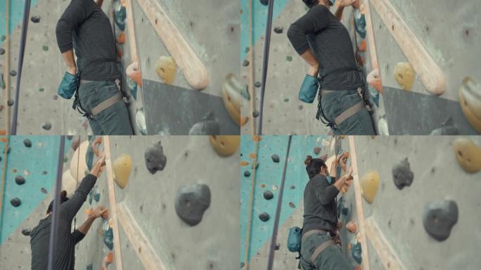男子在攀岩馆训练时，将镁涂在她的手上，慢动作