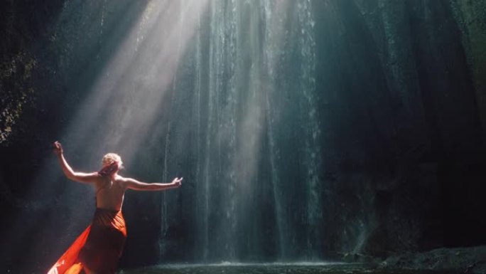 瀑布洞里跳舞的女人泼水穿着漂亮的衣服享受自然舞蹈感受精神自由4k
