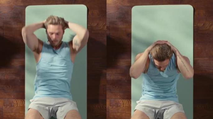 垂直屏幕顶视图运动: 漂亮的家伙躺在家里的运动垫上做腹肌仰卧起坐。肌肉发达，健康，非常英俊的运动员在