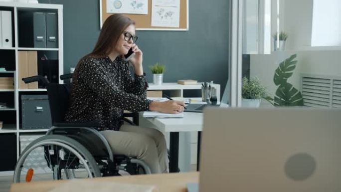 坐在轮椅上的残疾女商人在办公室打电话的慢动作