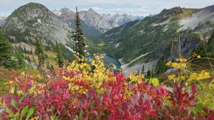 红黄的叶子在强大的山峰的背景。美国北喀斯喀特国家公园的山脉和湖泊。山里的秋天。美利坚合众国的性质，万