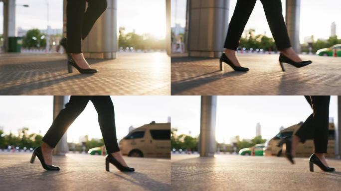 低角度视角的商业女性在日落时走在城市上