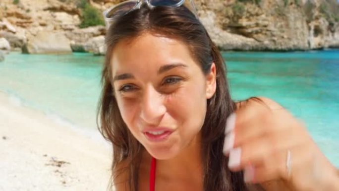 一个迷人的年轻女子站在意大利的海滩上吃西瓜的4k视频片段